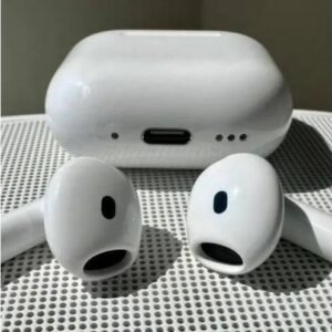 White wireless earbuds with their charging case on a perforated surface on a table.
