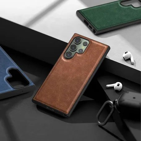 Brown leather smartphone case on a phone with multiple camera lenses, surrounded by blue and green phone cases and wireless earbuds on a desk