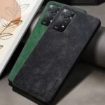 img_8294 - The Phonepreneur Global Textured black phone case with a green accent and dual-camera cutout, resting on a couch beside framed art.