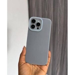 Person's hand holding a light gray silicone phone case around a smartphone with three rear camera lenses, against a wall background.