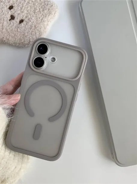 Gray phone case with a circular ring grip on the back, held by a hand near a laptop lid/edge.