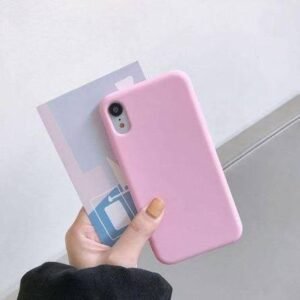 img_8358 - The Phonepreneur Global Person holding a pink smartphone case with a translucent card against a light wall.