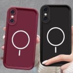 img_8360 - The Phonepreneur Global Two protective phone cases, burgundy and black, each with a white circular emblem and a short stem on the back, held by hands.