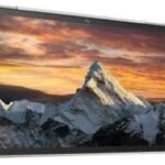 2-in-1 laptop with kickstand open, displaying a snowy mountain peak at sunset on the screen